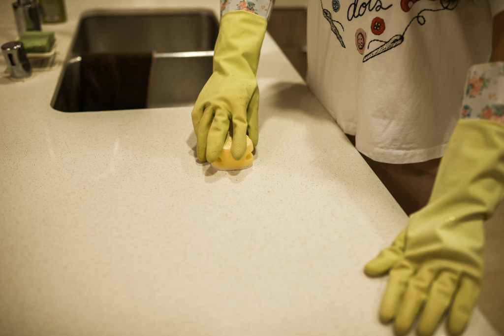 a person cleaning a kitchen counter
