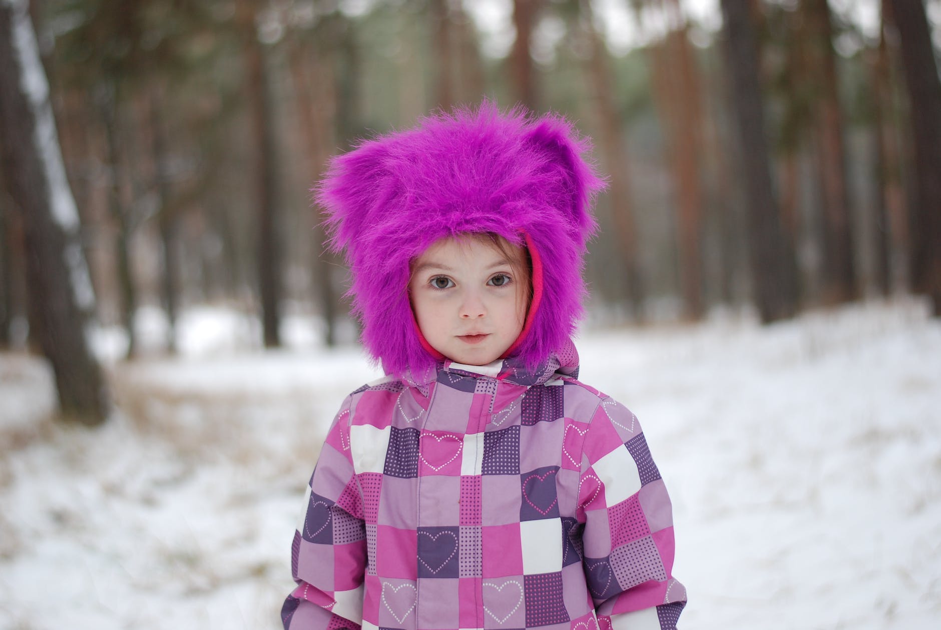 girl wearing pink hoodie standing near forest